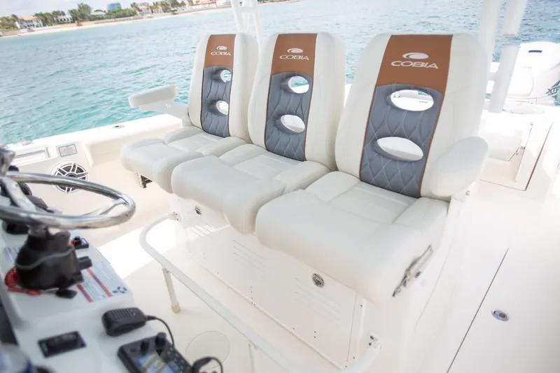 Slide: The Image of 2024 Cobia 350 CC boat with luxurious seating and ocean backdrop. - 15