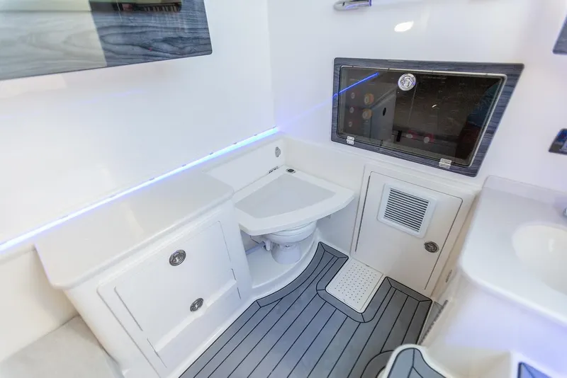 Slide: The Image of 2024 Cobia 350 CC boat interior bathroom with modern fixtures and storage cabinets. - 7