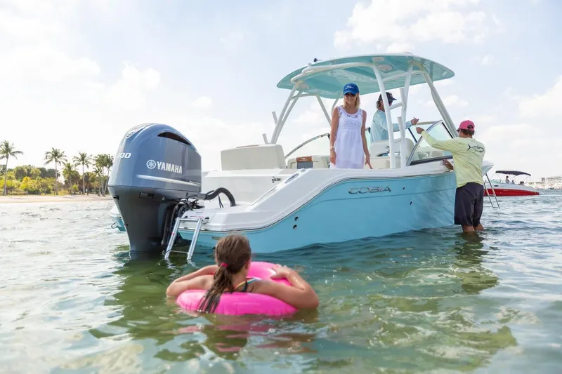 Slide: The Image of 2024 Cobia 240 Dual Console boat in shallow water with people enjoying the day. - 7
