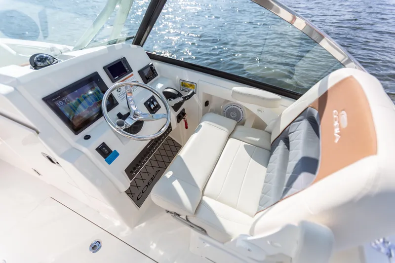 Slide: The Image of 2024 Cobia 240 Dual Console boat cockpit with modern controls and comfortable seating. - 9