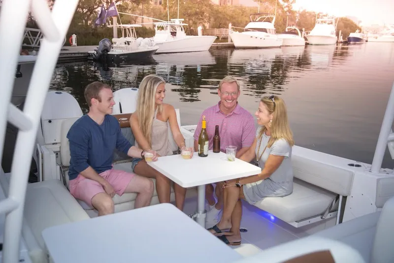 Slide: The Image of Four people enjoying drinks on a 2024 Cobia 280 Dual Console boat. - 18