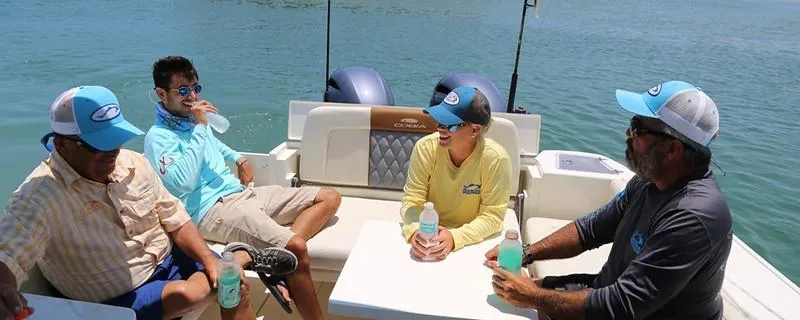 Slide: The Image of People relaxing on a 2024 Cobia 280 Dual Console boat, enjoying drinks. - 7