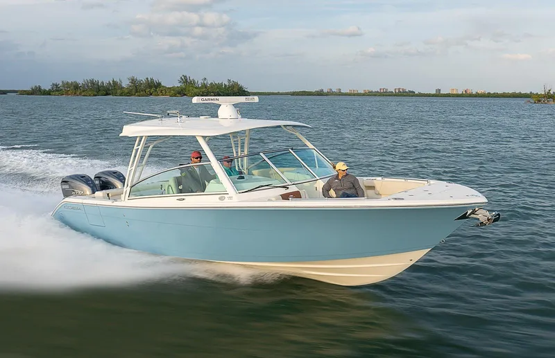 The Image of 2024 Cobia 330 Dual Console boat cruising on open water. - 1