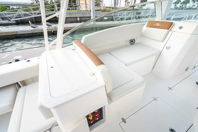 Slide: The Image of 2024 Cobia 330 Dual Console boat interior with white seating and storage compartments. - 10