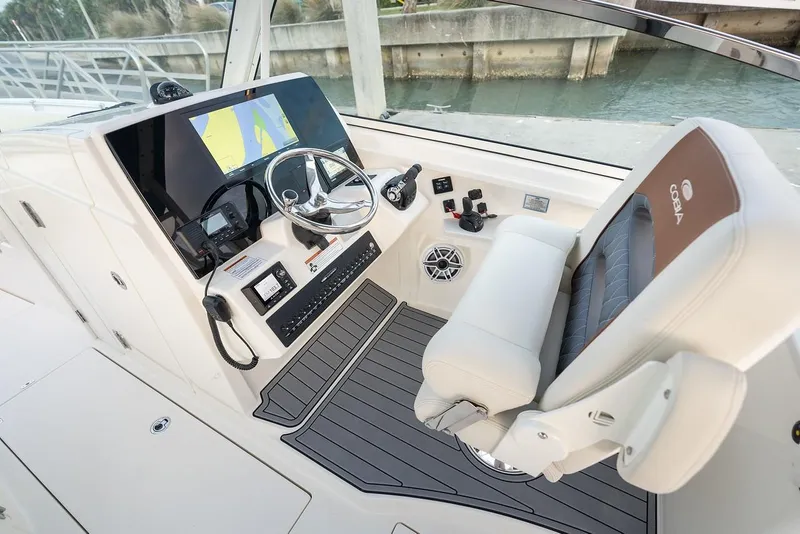 Slide: The Image of 2024 Cobia 330 Dual Console boat cockpit with modern steering and navigation system. - 13