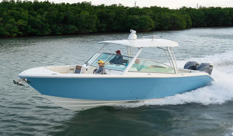 Slide: The Image of 2024 Cobia 330 Dual Console boat cruising on water. - 3