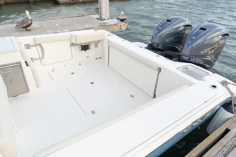 Slide: The Image of 2024 Cobia 330 Dual Console boat with twin outboard engines at dock. - 4