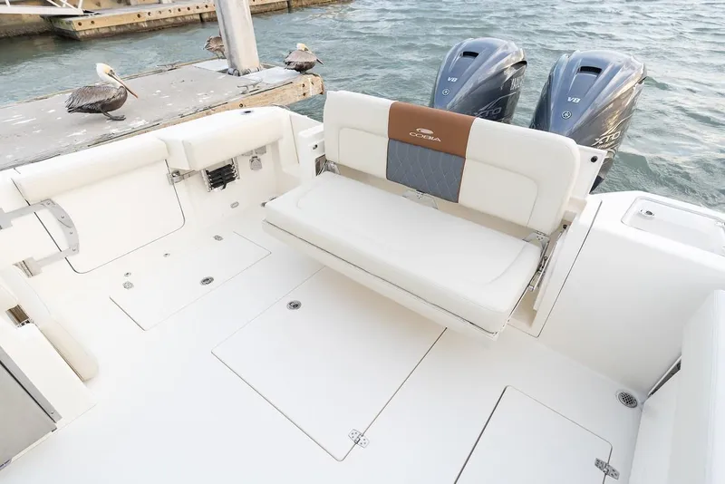 Slide: The Image of 2024 Cobia 330 Dual Console boat with twin outboard engines and foldable seating. - 5