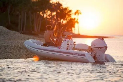 Slide: The Image of 2024 Grand Inflatables S420 boat at sunset with couple on board. - 1