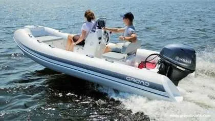 Slide: The Image of 2024 Grand Inflatables S420 boat cruising on water with two passengers. - 10