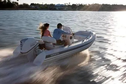 Slide: The Image of 2024 Grand Inflatables S420 boat cruising on water at sunset. - 3