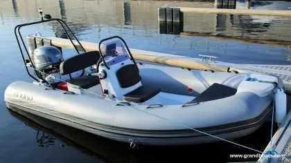 Slide: The Image of 2024 Grand Inflatables S420 boat docked on calm water. - 6