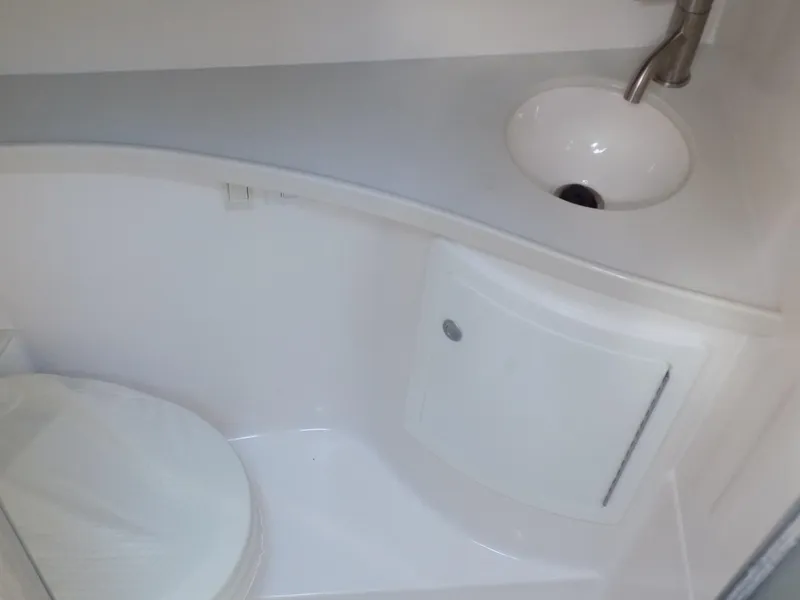 Slide: The Image of 2022 Regal 28 Express boat bathroom with sink and toilet. - 13