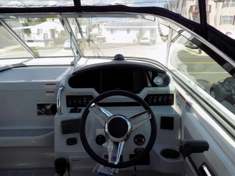 Slide: The Image of 2022 Regal 28 Express boat cockpit with steering wheel and dashboard controls. - 6