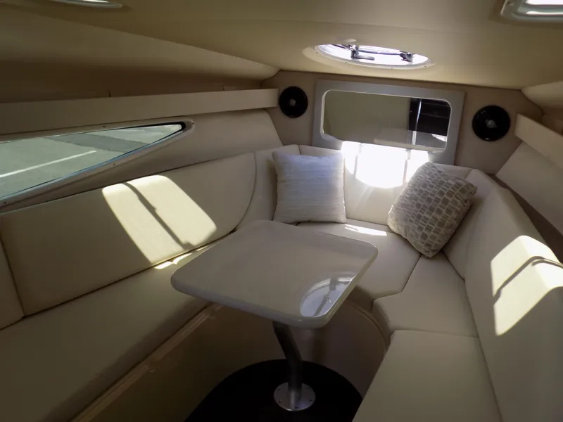 Slide: The Image of 2022 Regal 28 Express cabin interior with plush seating and table. - 8