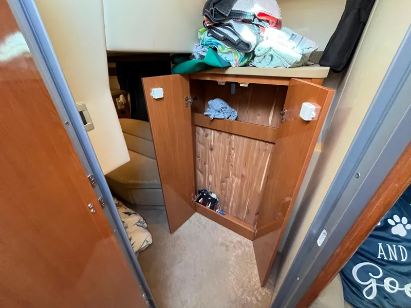 Slide: The Image of Open cabinet in 2009 Maxum 3100 SE boat interior with clothes. - 13