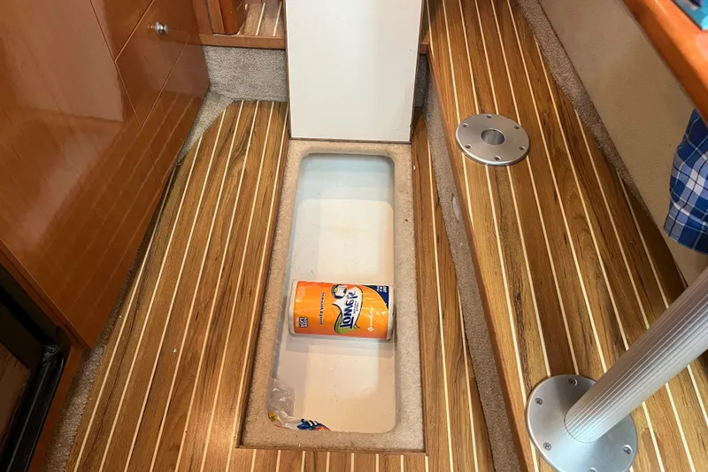 Slide: The Image of 2009 Maxum 3100 SE boat interior with wooden flooring and storage compartment. - 19