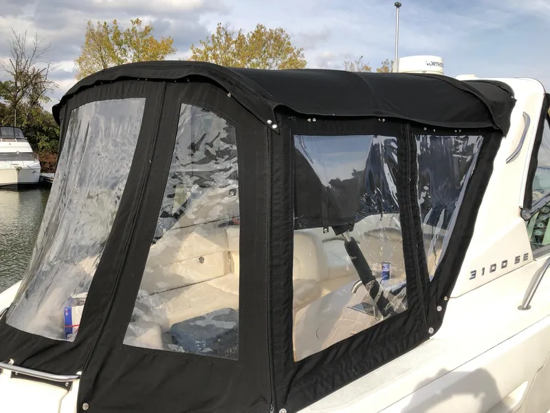 Slide: The Image of 2009 Maxum 3100 SE boat with black canvas enclosure docked. - 2