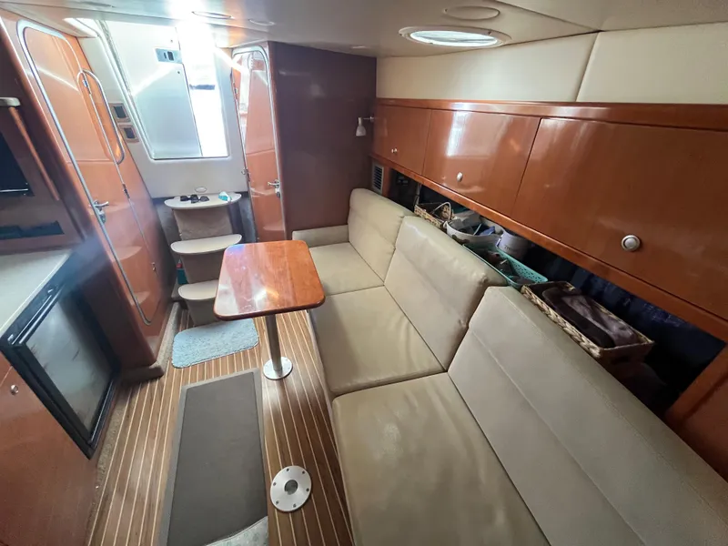 Slide: The Image of Interior of 2009 Maxum 3100 SE boat with beige seating and wooden cabinetry. - 34