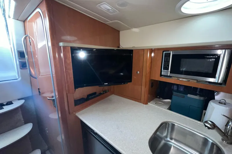 Slide: The Image of 2009 Maxum 3100 SE boat interior with TV, microwave, and sink. - 38