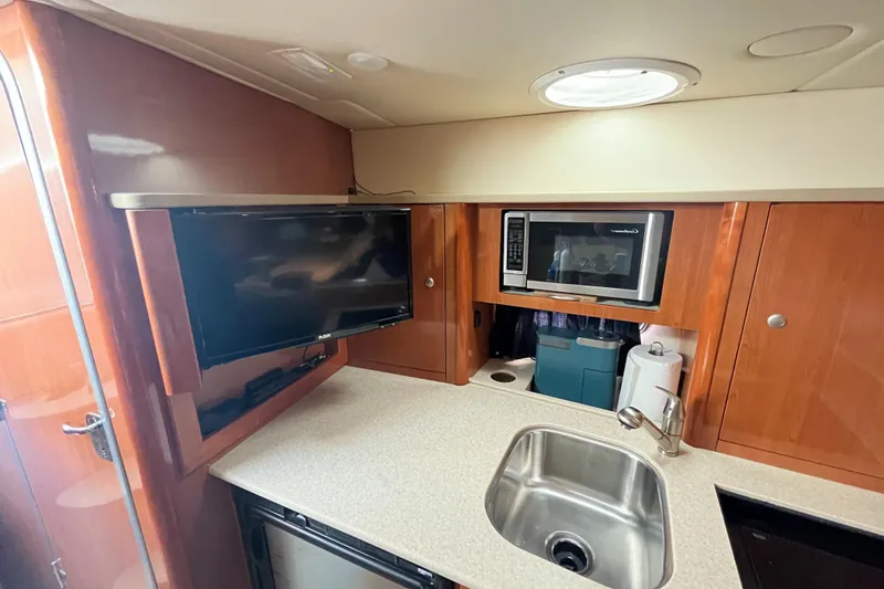 Slide: The Image of 2009 Maxum 3100 SE boat interior kitchen with TV, microwave, and sink. - 39