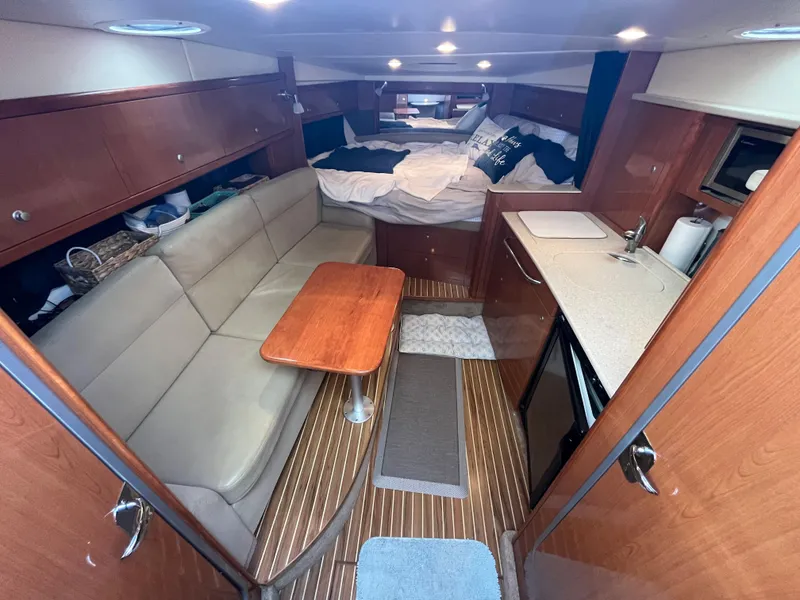 Slide: The Image of 2009 Maxum 3100 SE cabin interior with seating, table, and bed. - 41