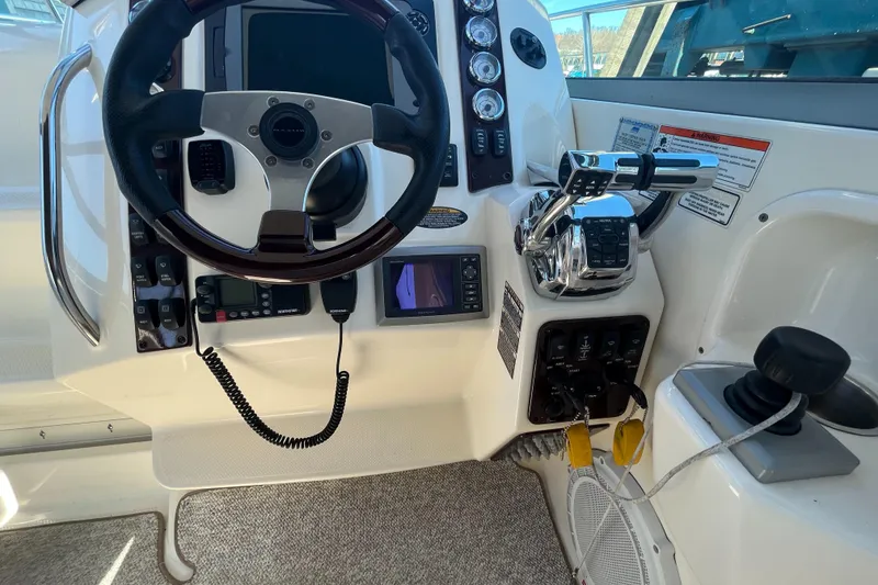 Slide: The Image of Control panel of a 2009 Maxum 3100 SE boat with steering wheel and throttle. - 7