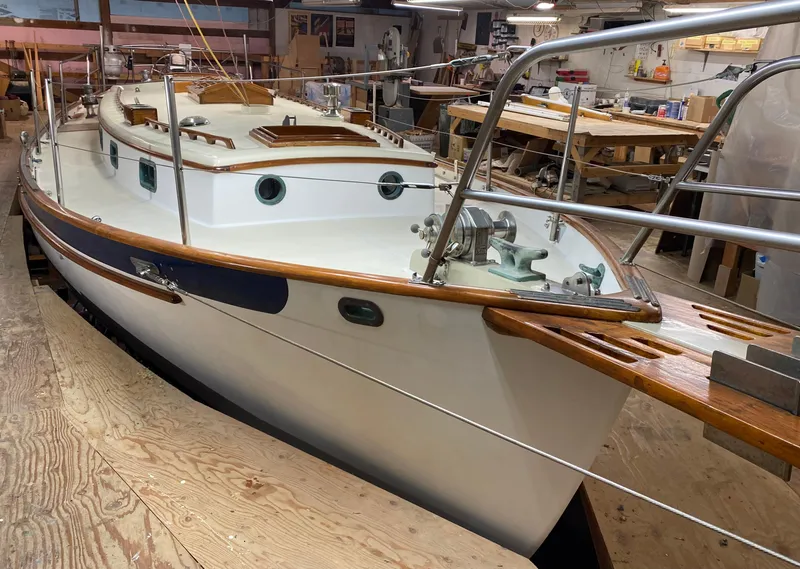 Slide: The Image of 1988 Cape George 38 sailboat in a workshop, showcasing classic design and craftsmanship. - 2