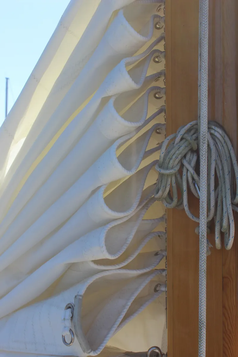 Slide: The Image of Folded sail on a 1988 Cape George 38 boat, with ropes and wooden mast. - 27