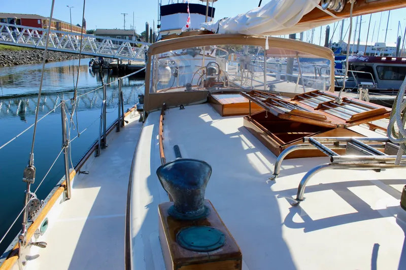 Slide: The Image of 1988 Cape George 38 sailboat deck with wooden accents and marina background. - 28