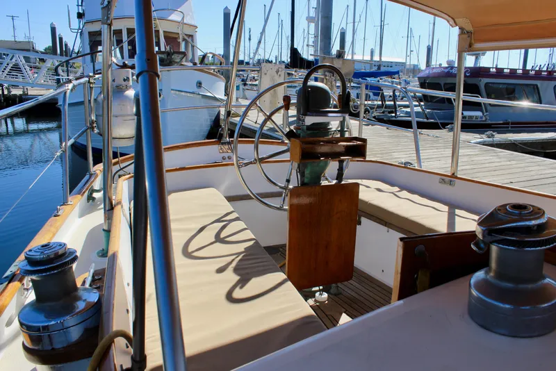 Slide: The Image of 1988 Cape George 38 sailboat cockpit with steering wheel, docked at marina. - 31