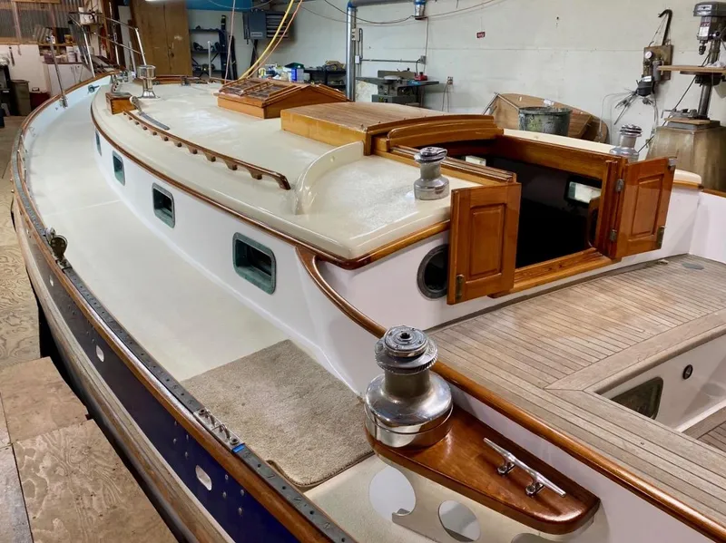 Slide: The Image of 1988 Cape George 38 sailboat with wooden deck and open cabin in a workshop. - 4