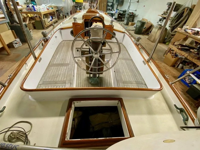 Slide: The Image of 1988 Cape George 38 sailboat interior with wooden deck and steering wheel in workshop. - 5