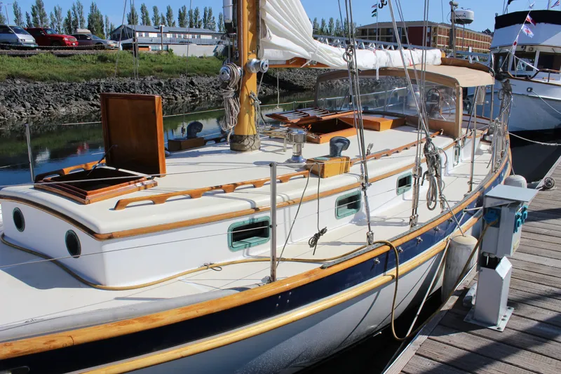 Slide: The Image of 1988 Cape George 38 sailboat docked, featuring classic design and wooden accents. - 8