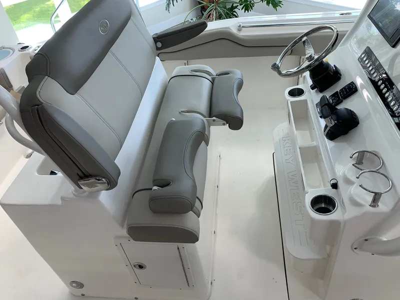 Slide: The Image of 2024 Key West 263 FS boat interior with dual helm seats and steering console. - 15