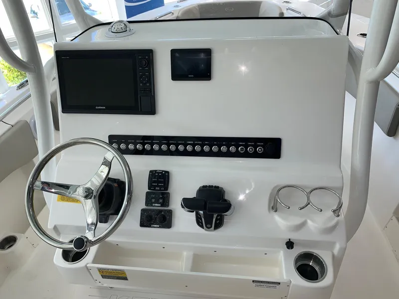 Slide: The Image of 2024 Key West 263 FS boat dashboard with steering wheel, navigation system, and control panel. - 14