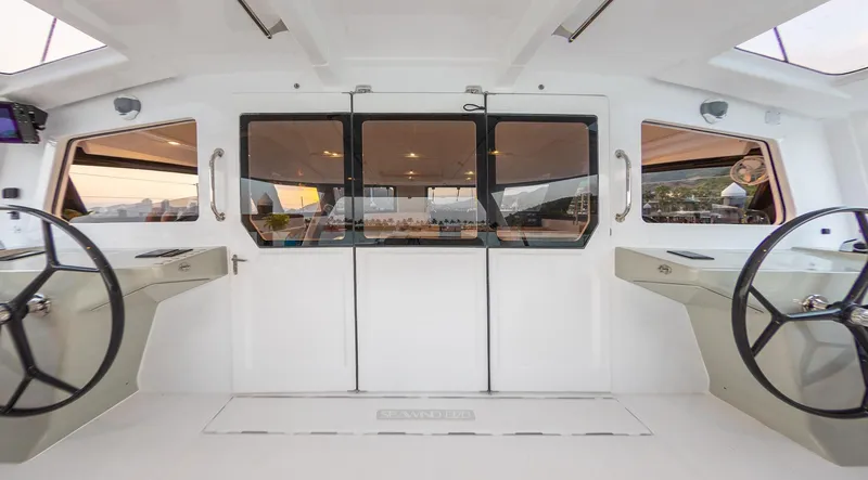 Slide: The Image of 2025 Seawind 1370 catamaran cockpit with dual steering wheels and panoramic windows. - 8