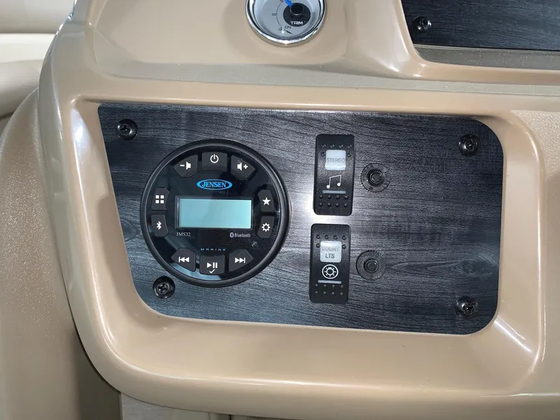 Slide: The Image of 2024 Starcraft LX22 F boat control panel with Jensen audio system and switches. - 11