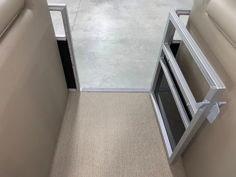 Slide: The Image of 2024 Starcraft LX22 F boat interior with beige upholstery and open gate. - 17