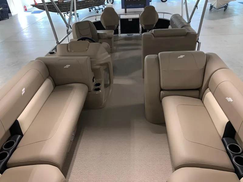 Slide: The Image of 2024 Starcraft LX22 F pontoon boat interior with beige seating and cup holders. - 5
