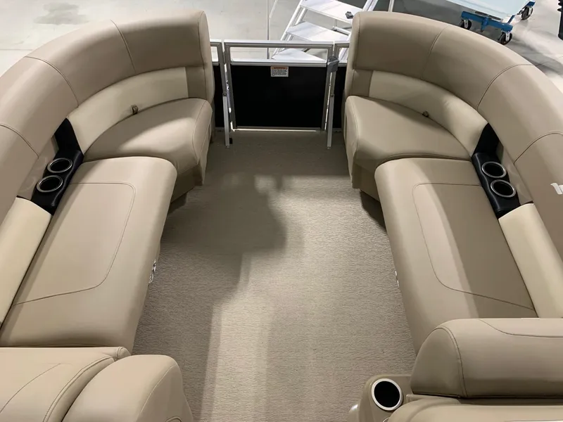Slide: The Image of 2024 Starcraft LX22 R pontoon boat interior with beige seating and cup holders. - 15