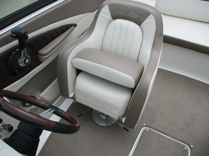 Slide: The Image of The interior of a 2013 Sea Ray 210 SLX featuring a cushioned captain's chair and steering wheel. - 15