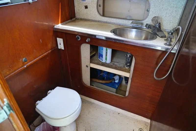Slide: The Image of 1962 Chris-Craft Roamer 36 boat bathroom with sink, toilet, and storage cabinet. - 12