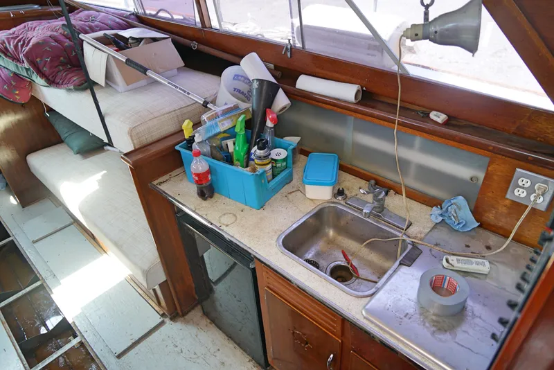 Slide: The Image of Interior of a 1962 Chris-Craft Roamer 36 boat with a cluttered kitchen area. - 8