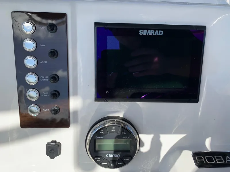 Slide: The Image of 2024 Robalo R202 Explorer dashboard with Simrad display and Clarion audio controls. - 14