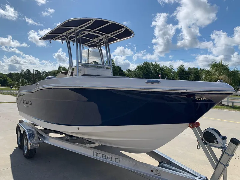 Slide: The Image of 2024 Robalo R202 Explorer boat on a trailer under a sunny sky. - 3