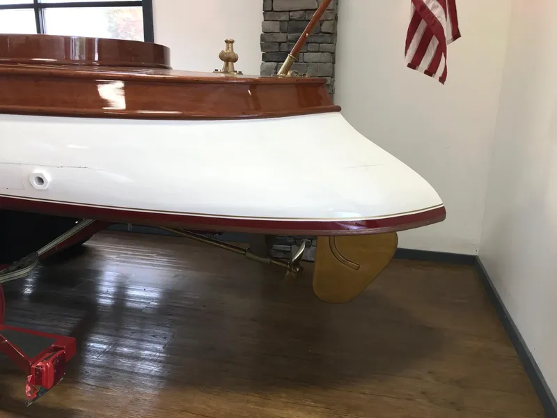 Slide: The Image of Vintage 1905 New York Launch 20 boat on display indoors with American flag. - 2