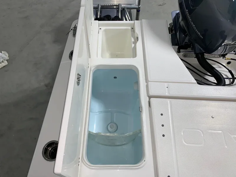 Slide: The Image of 2024 Robalo 226 Cayman boat livewell and storage compartments. - 8
