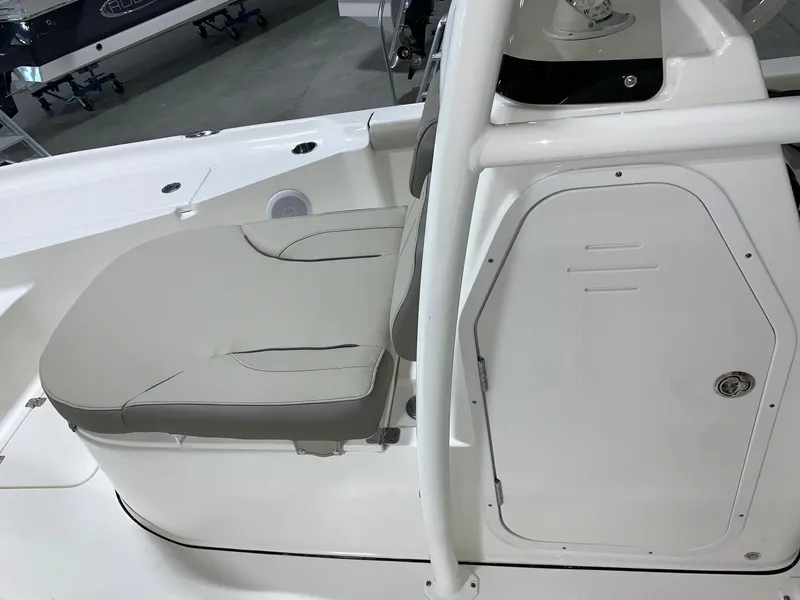 Slide: The Image of 2024 Key West 250 Bay Reef boat interior with cushioned seating and storage compartment. - 20