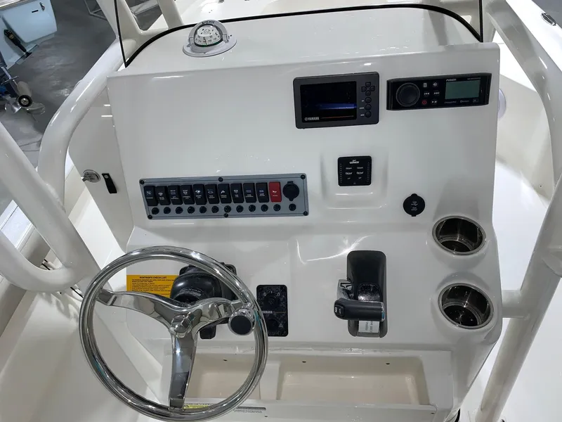 Slide: The Image of 2024 Key West 250 Bay Reef boat console with steering wheel and control panel. - 24